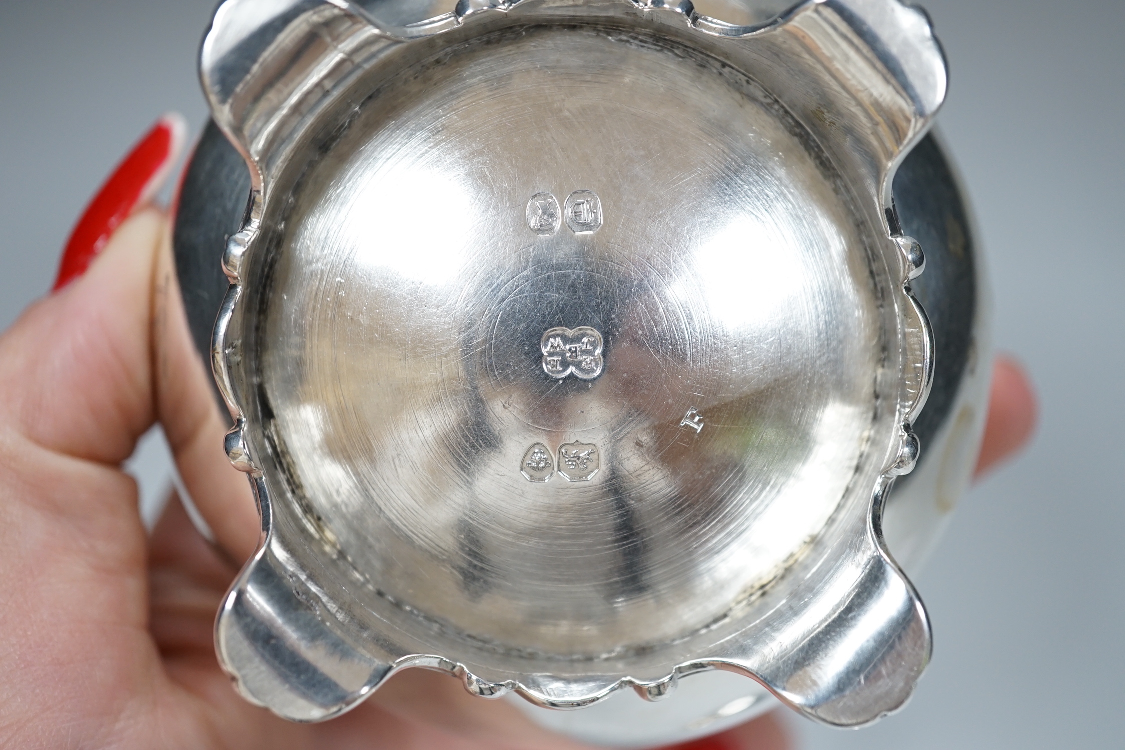 A pair of Victorian circular silver salts, with crests and scroll feet, makers Edward Barnard & Sons, London 1839, 207 grams, and a pair of George IV silver salt spoons, London 1827, 19 grams